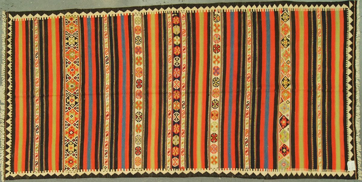 Striped rug with vertical bands of orange, brown, and purple with decorative central stripe and edge trim