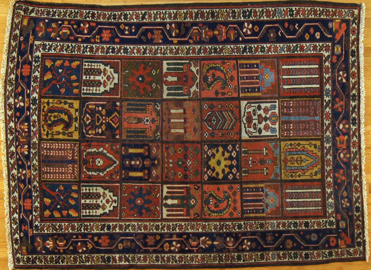 Oriental rug with a dark blue border and a grid of colorful, patterned squares