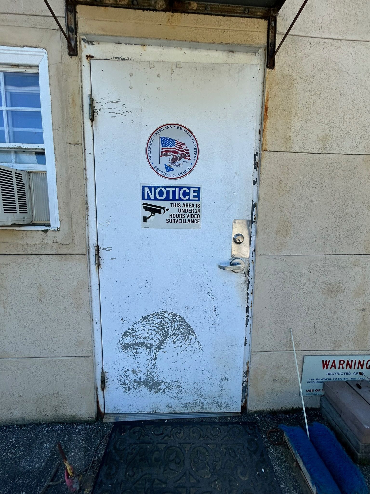 White door with peeling paint and two notices attached.