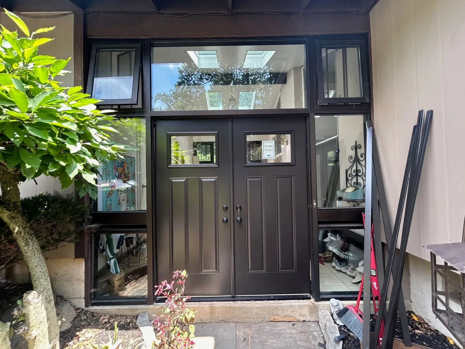 Brown double doors with sidelights and transom windows. Exterior view.