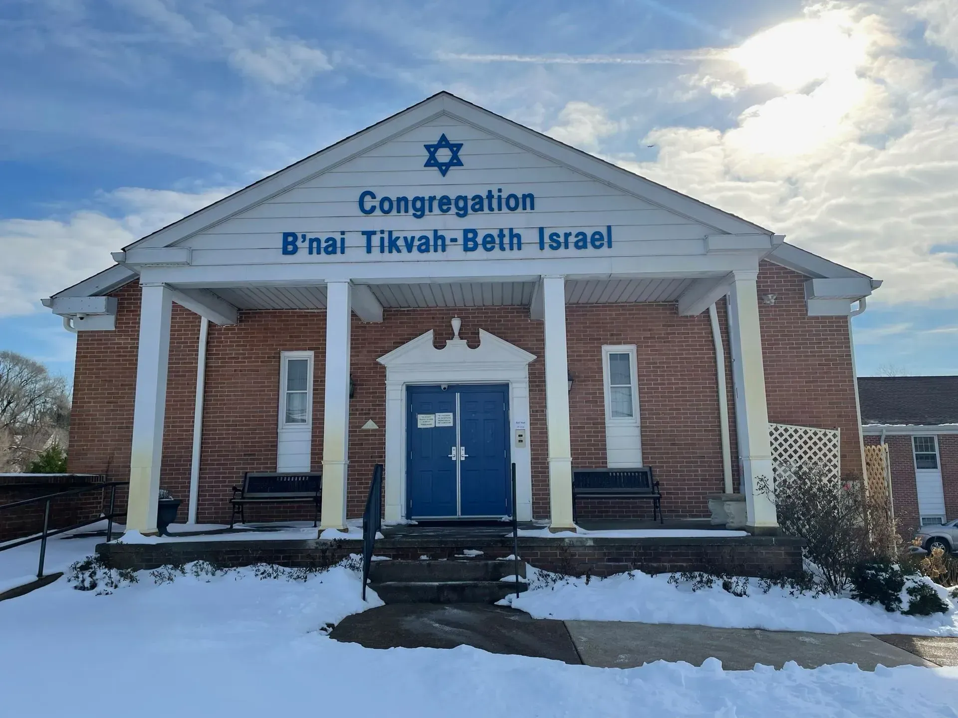 Congregation B'nai Tikvah-Beth Israel building with blue doors, Star of David, and snow.