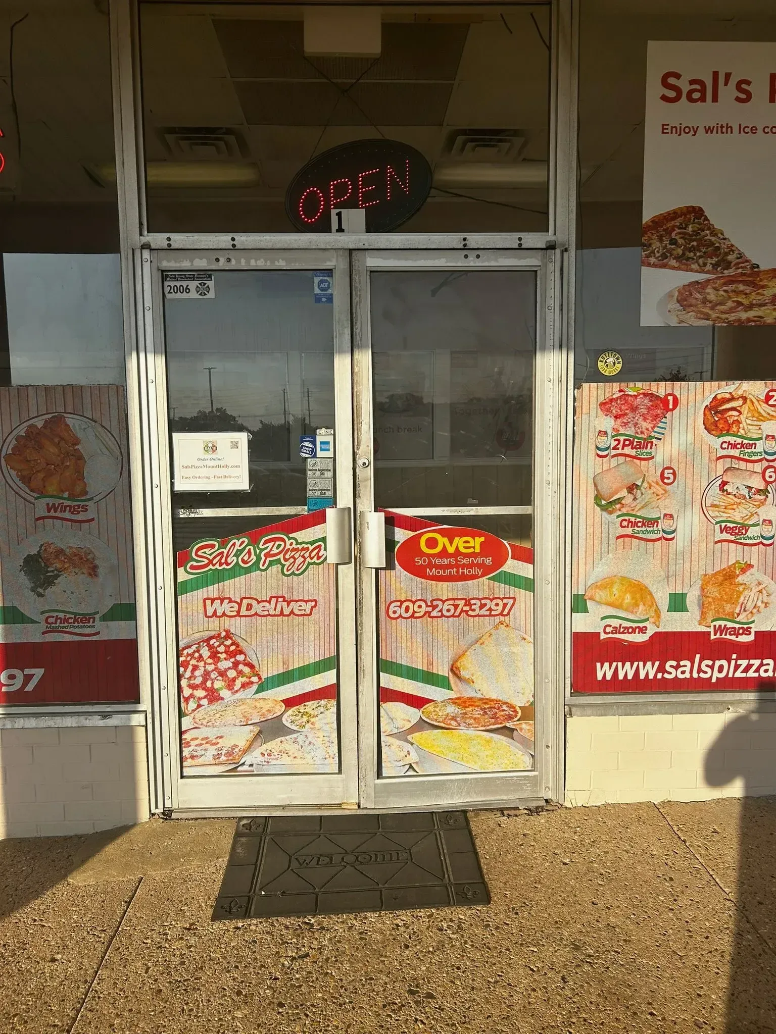 Sal's Pizza storefront with glass doors, a red 