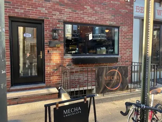 Exterior view of Mecha Chocolate shop with brick facade and sign.