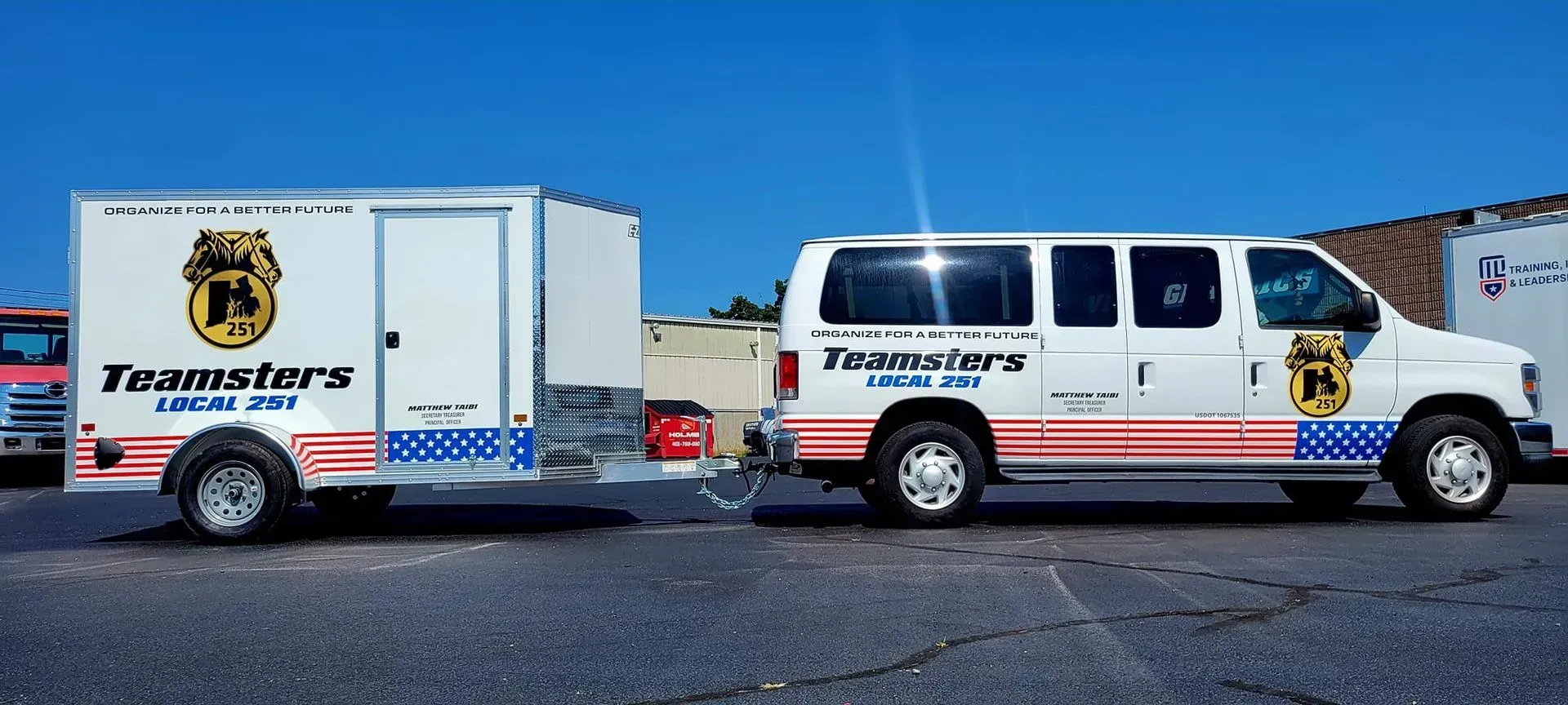 A white van towing a white trailer, both with 