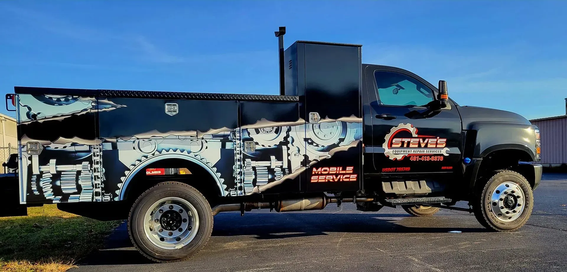Black mobile service truck with a stylized graphic of engine parts and the company logo.
