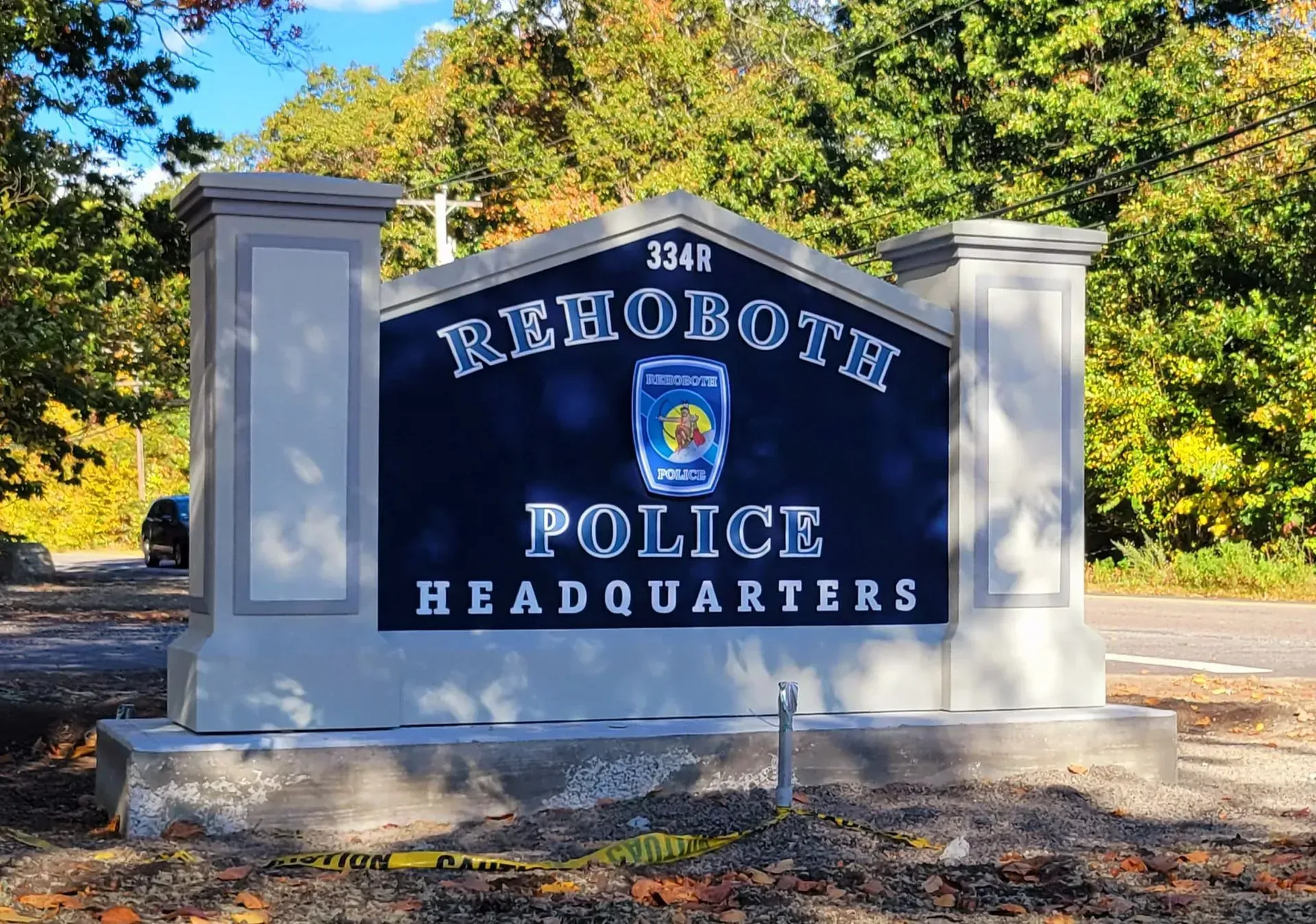 Rehoboth Police Headquarters sign with dark blue background and the town seal; gray and light gray pillars in the background.