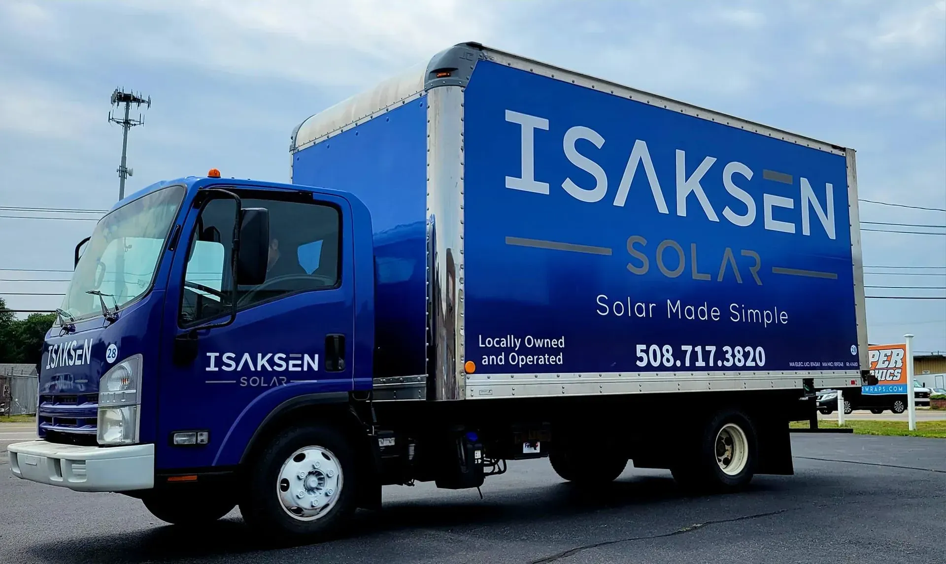 Blue Isaksen Solar truck with logo and phone number parked outdoors.