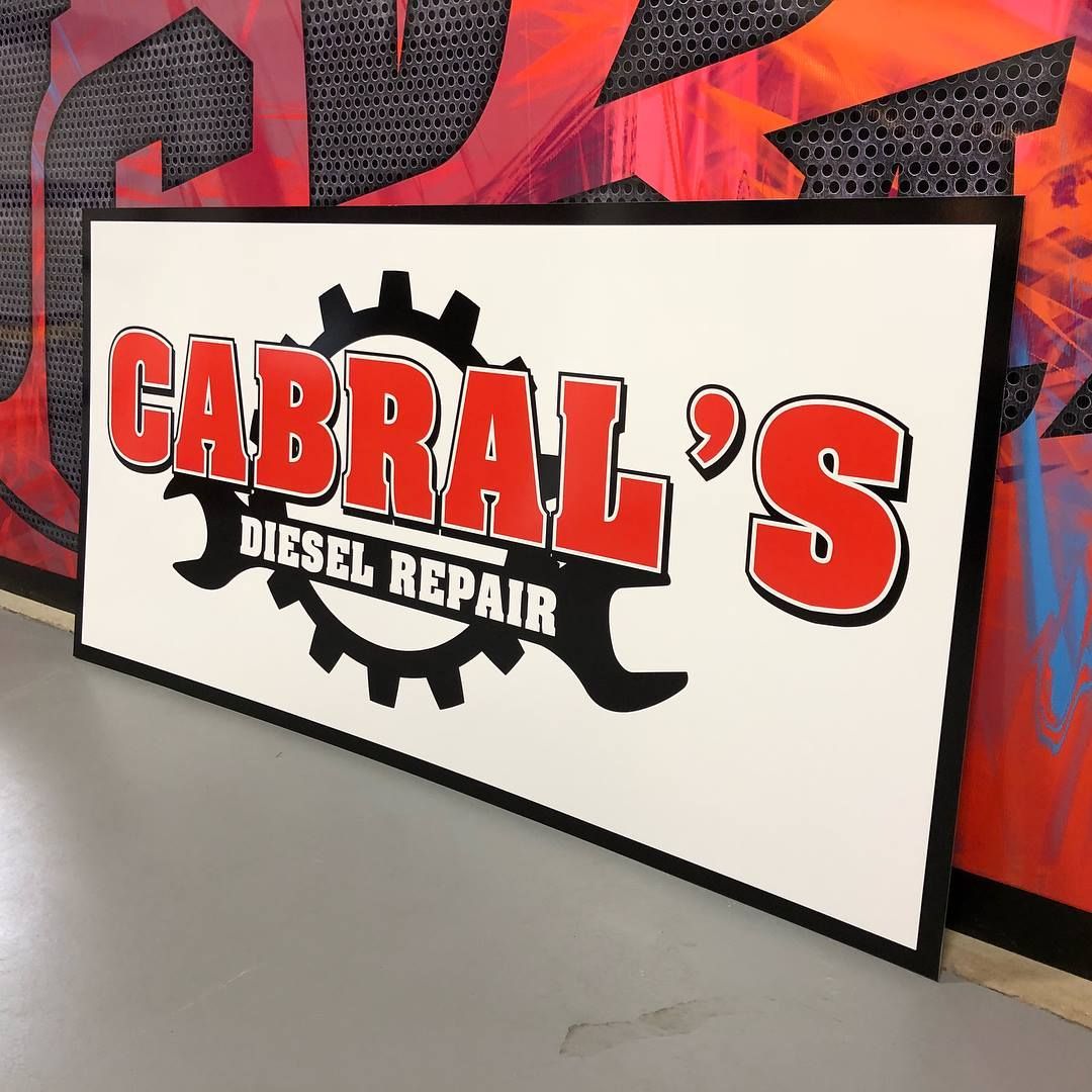 Cabral's Diesel Repair sign with red and black lettering on a white background, set against a colorful mural.
