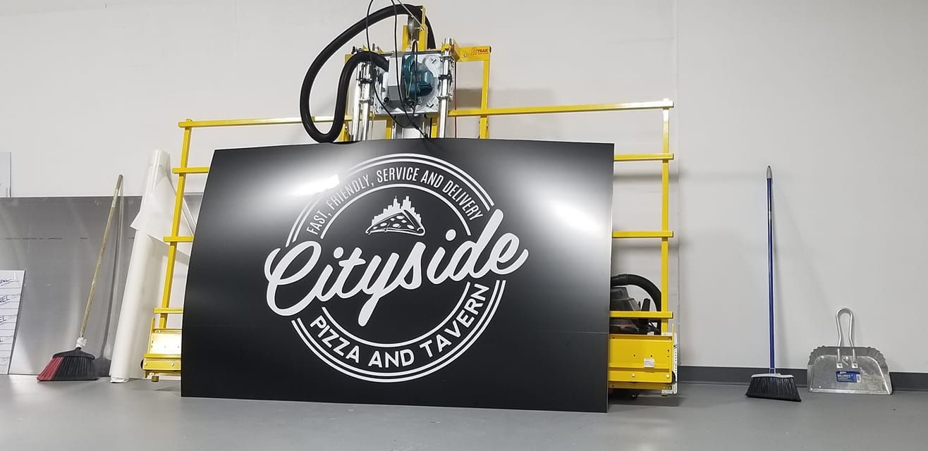 Cityside Pizza and Tavern sign propped against a lift in a workshop.