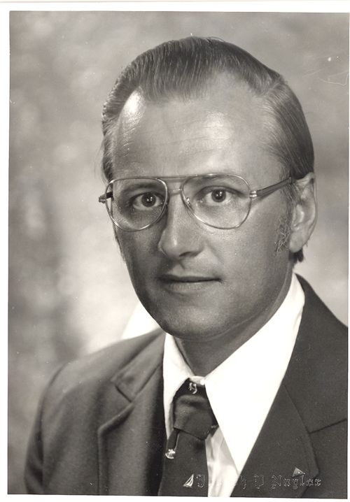 A black and white photo of a man in a suit and tie