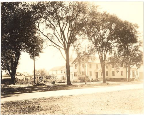 A black and white photo of a building with trees in front of it