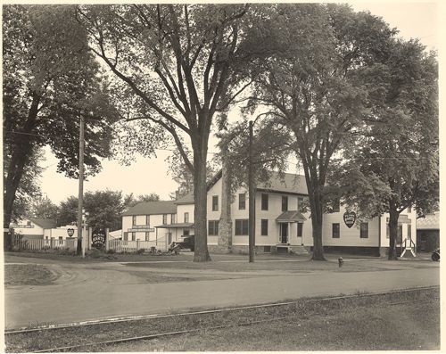 A black and white photo of a house surrounded by trees