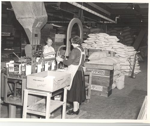 A black and white photo of a woman working in a factory