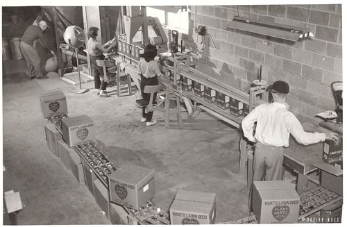 A black and white photo of people working in a factory