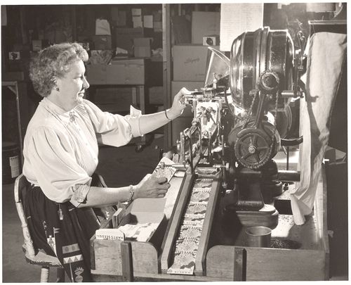 A woman is working on a machine in a black and white photo