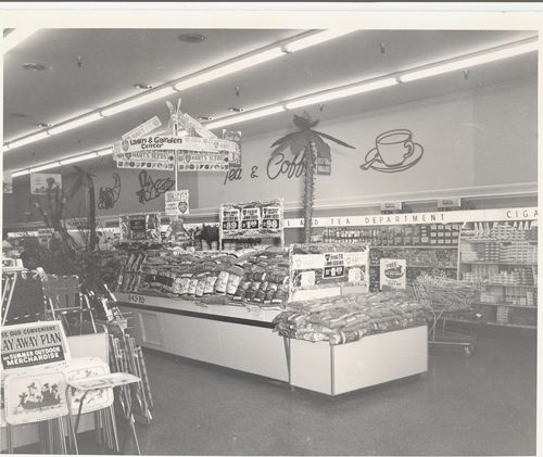 A black and white photo of the inside of a grocery store