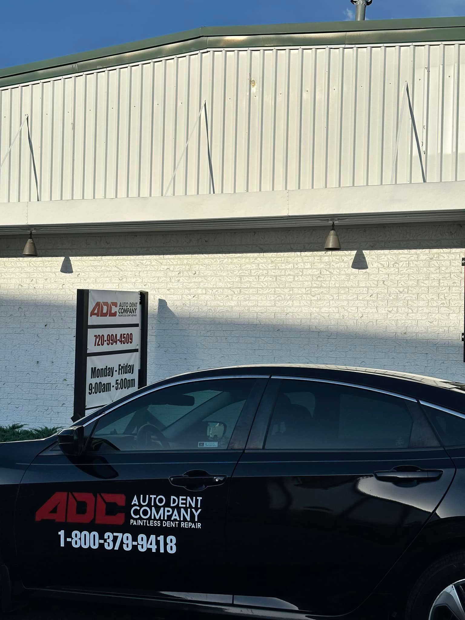 A black car with adc company written on the side