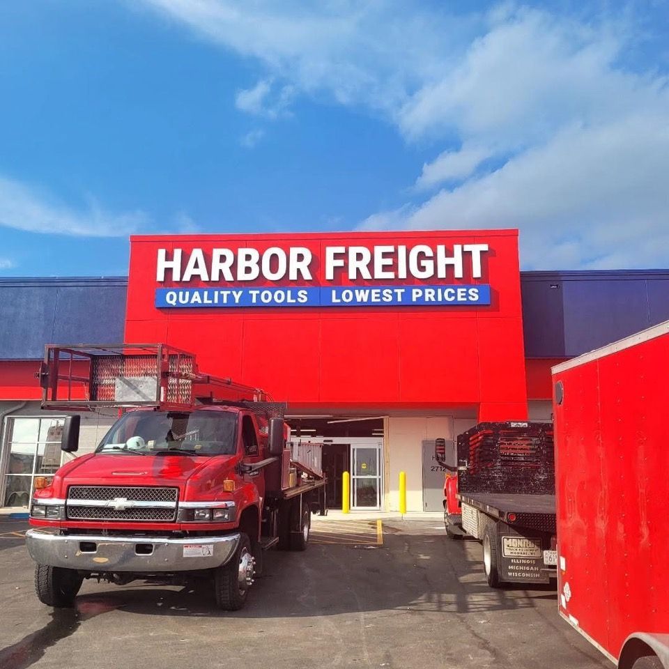 Exterior of a Harbor Freight store with red sign, truck, and blue sky.