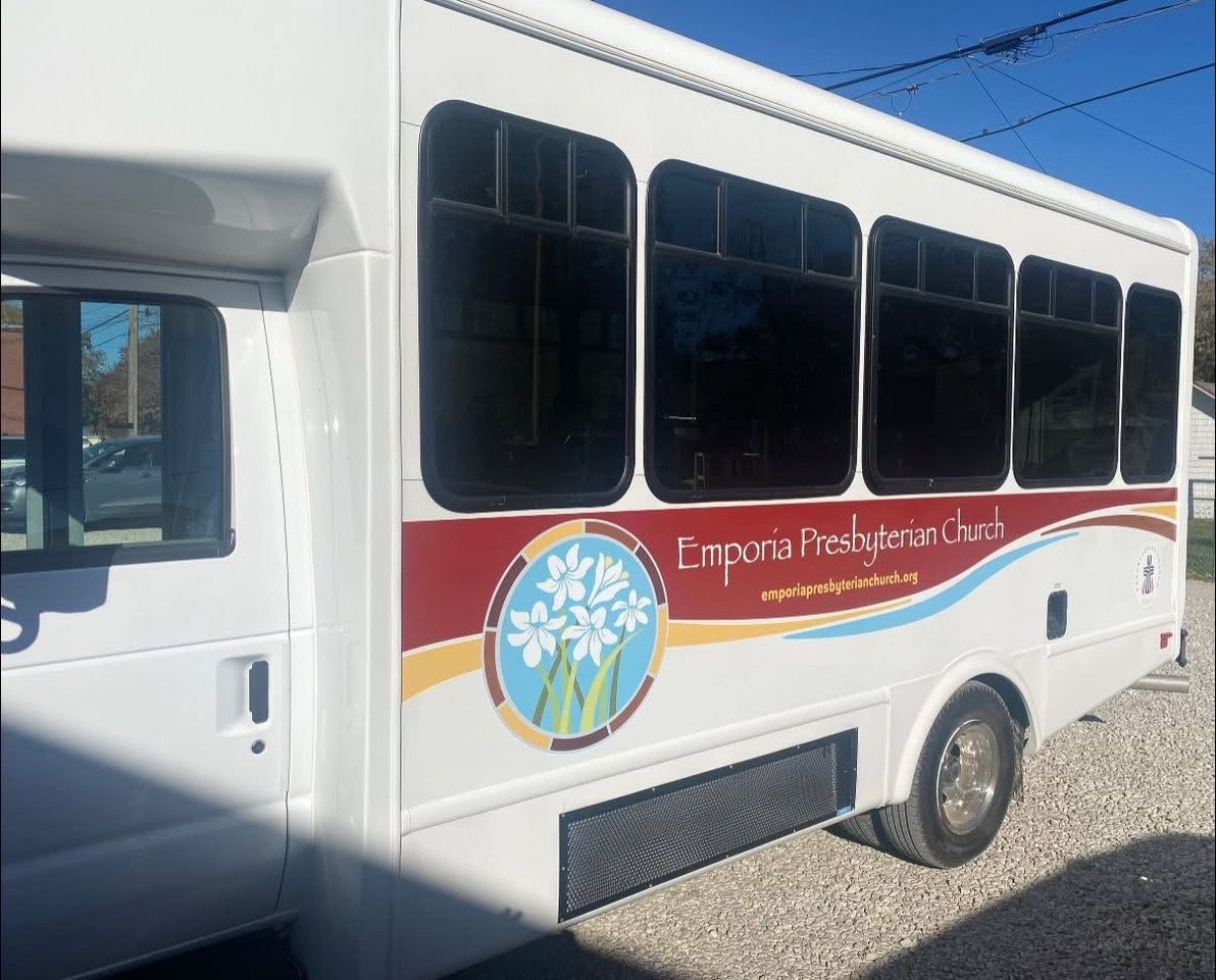 White bus with 'Cincinnati Inspire Coach' logo, dark-tinted windows, parked outdoors.