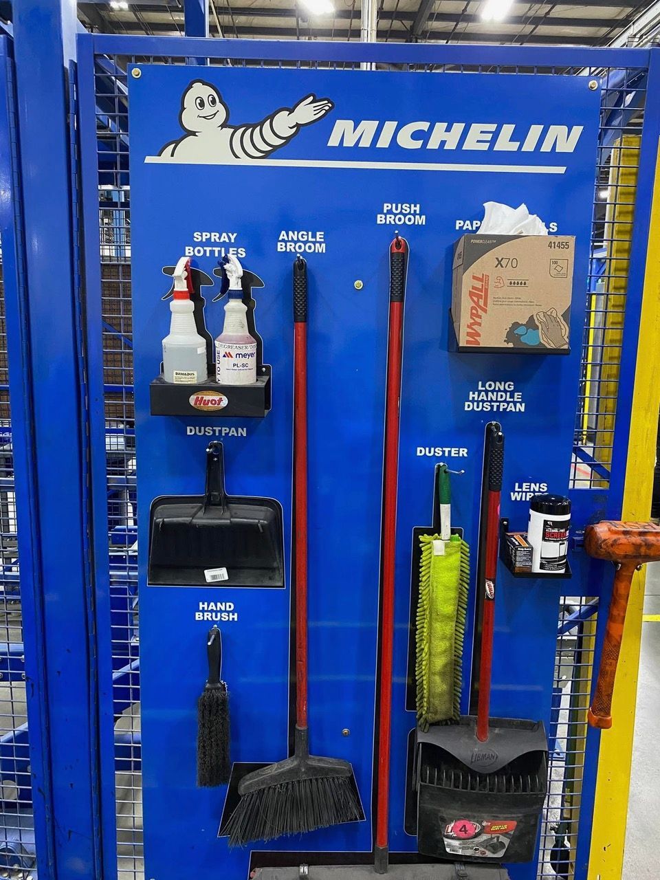 Blue Michelin-branded cleaning station with brooms, dustpans, and cleaning supplies.