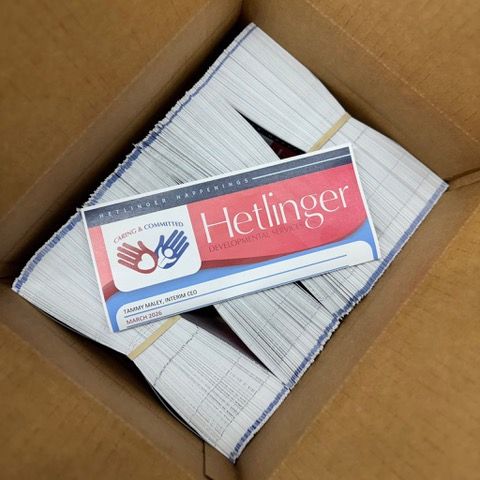 Box of Hetlinger business cards with bundles of cards and a rubber band.