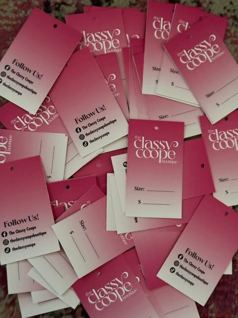 Pink and white clothing tags with The Classy Coupe logo, social media handles, and size/name sections.