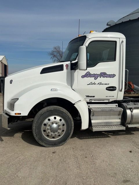 White Kenworth semi-truck with Lazy River logo parked outdoors.