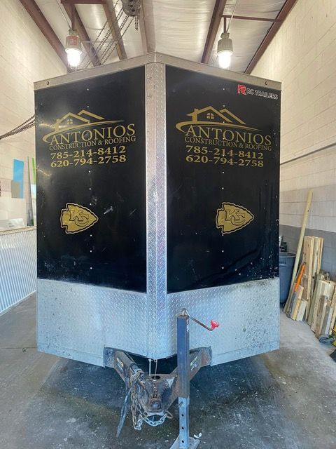 Black trailer with Antonios' logo and phone number. Diamond plate bottom, black top, with gold graphic.