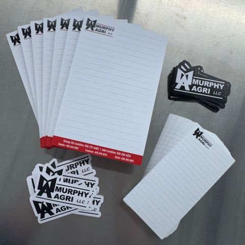 Stationery set, notepads with red borders, stacked, and logo stickers with the company name, Murphy Agri LLC.