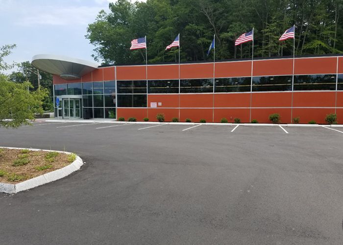A large building with a lot of windows and american flags flying in front of it.