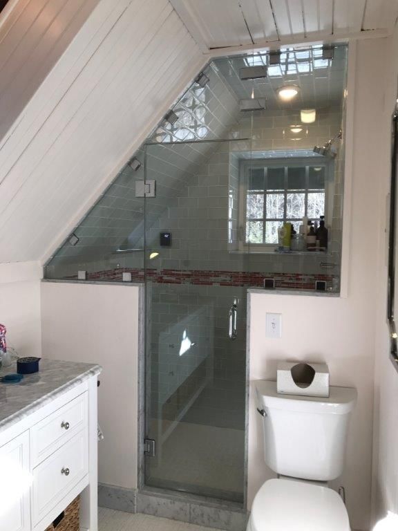 A bathroom with a toilet and a glass shower door