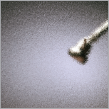 A blurred image of a screw on a gray surface