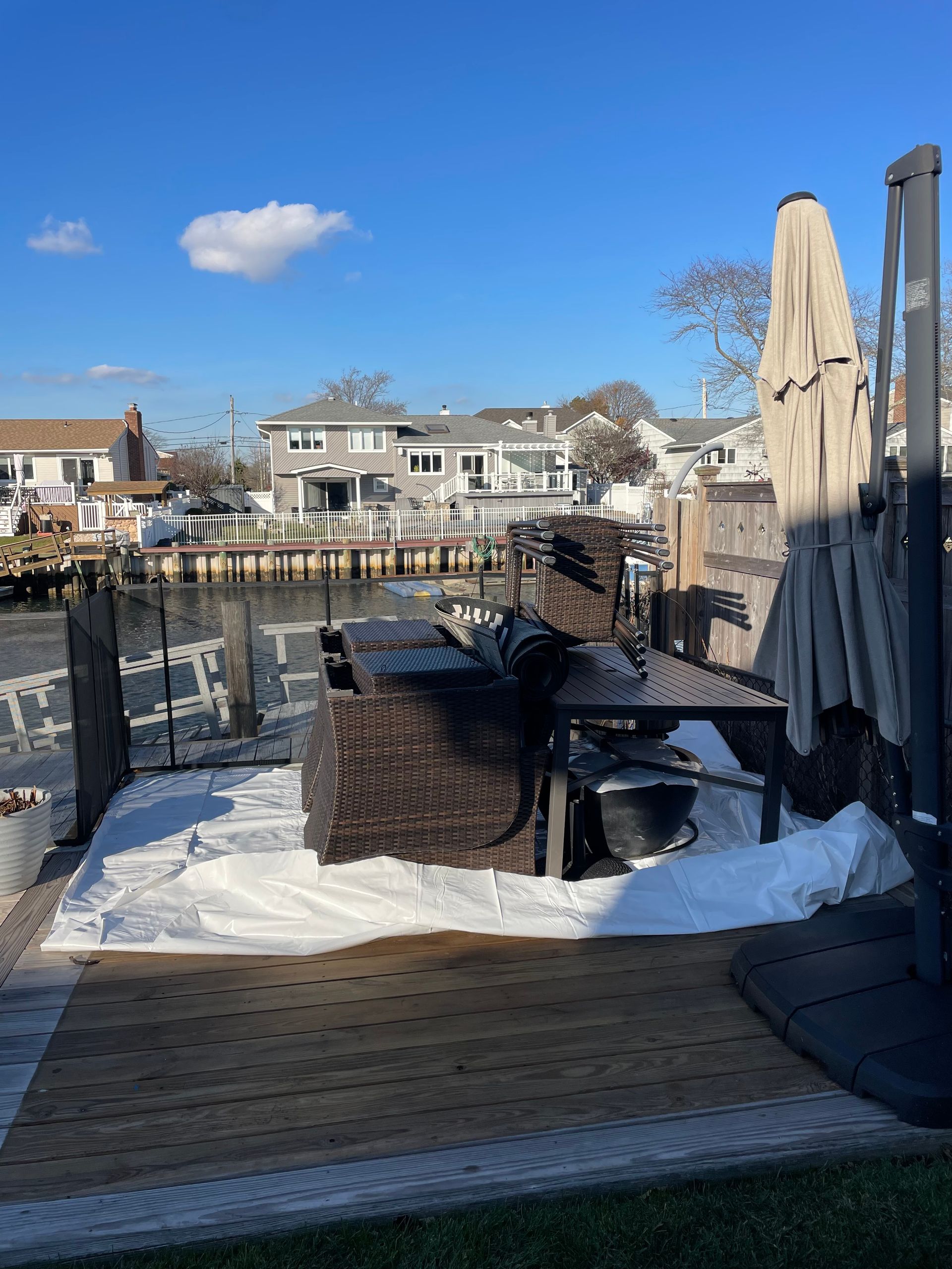A patio with a table and chairs next to a body of water