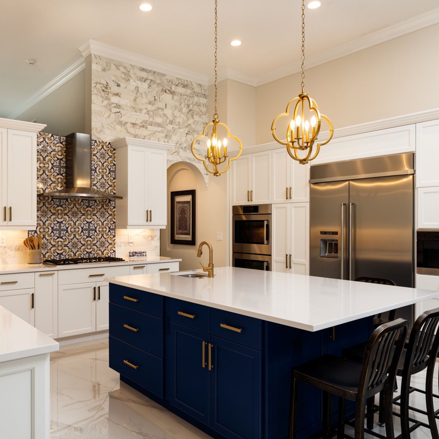 A kitchen with blue cabinets , white counter tops , stainless steel appliances and a large island.