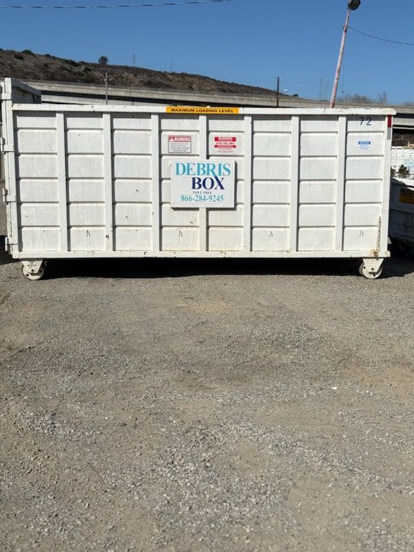 A white dumpster with a sign that says debris box