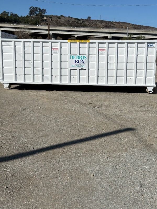 A large white dumpster with a sign on it that says ' debris ira '