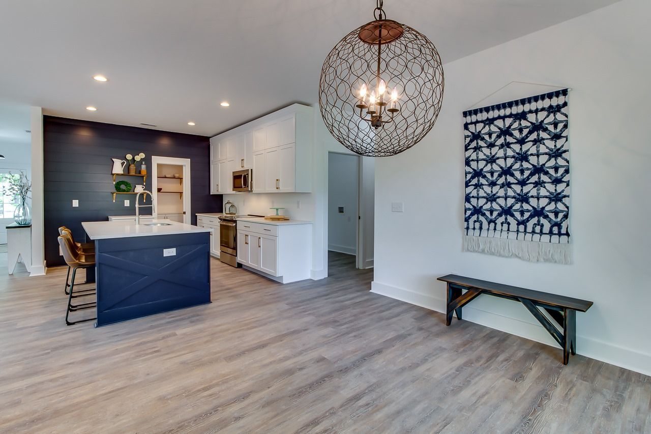 A kitchen with a large island and a chandelier hanging from the ceiling.