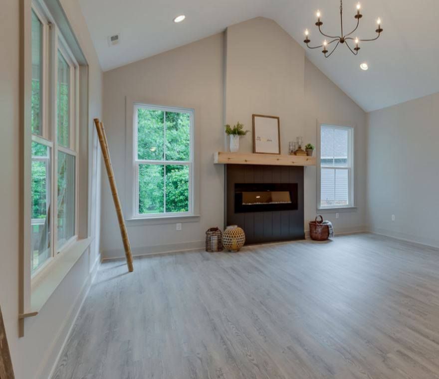 A living room with a fireplace and lots of windows