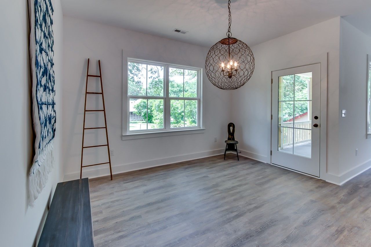 An empty room with a ladder and a chandelier hanging from the ceiling