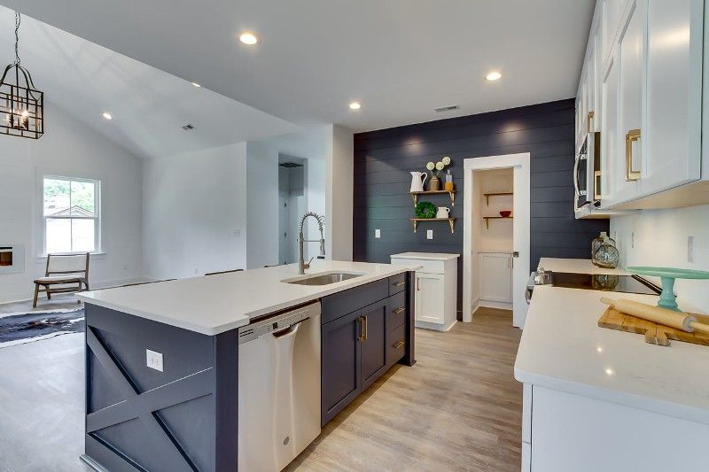 A kitchen with a large island and white cabinets
