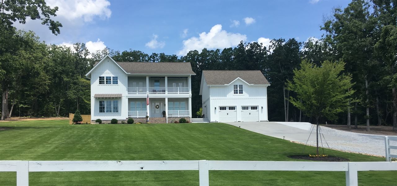 A large white house with a white fence in front of it