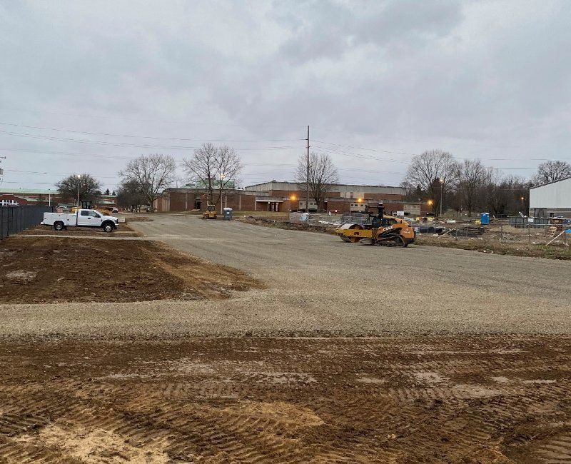 A forklift is driving down a dirt road.