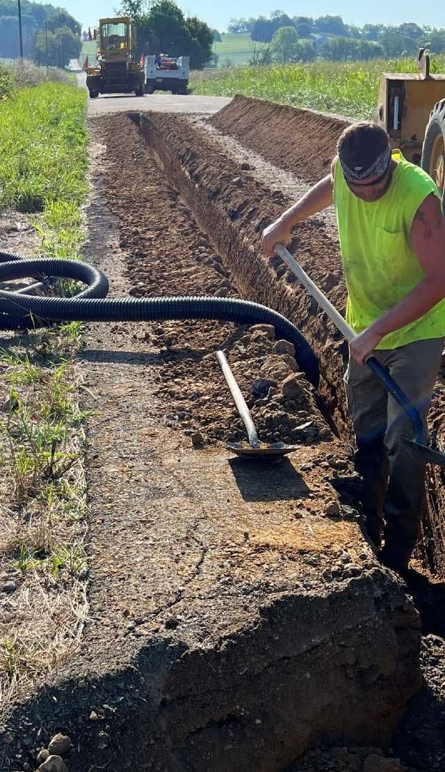 A man is digging a hole in the dirt with a shovel.