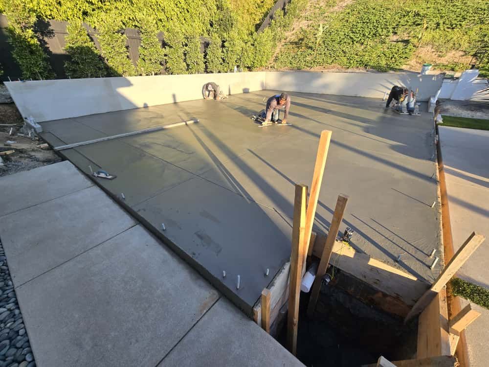 Roof under construction with fresh gray membrane, workers, and wooden framing opening