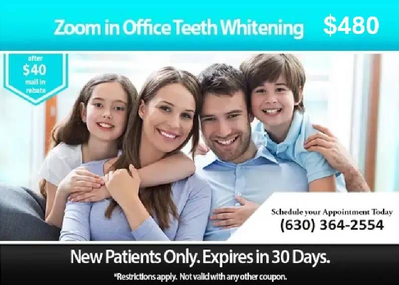 A family is smiling for a picture while sitting on a couch.