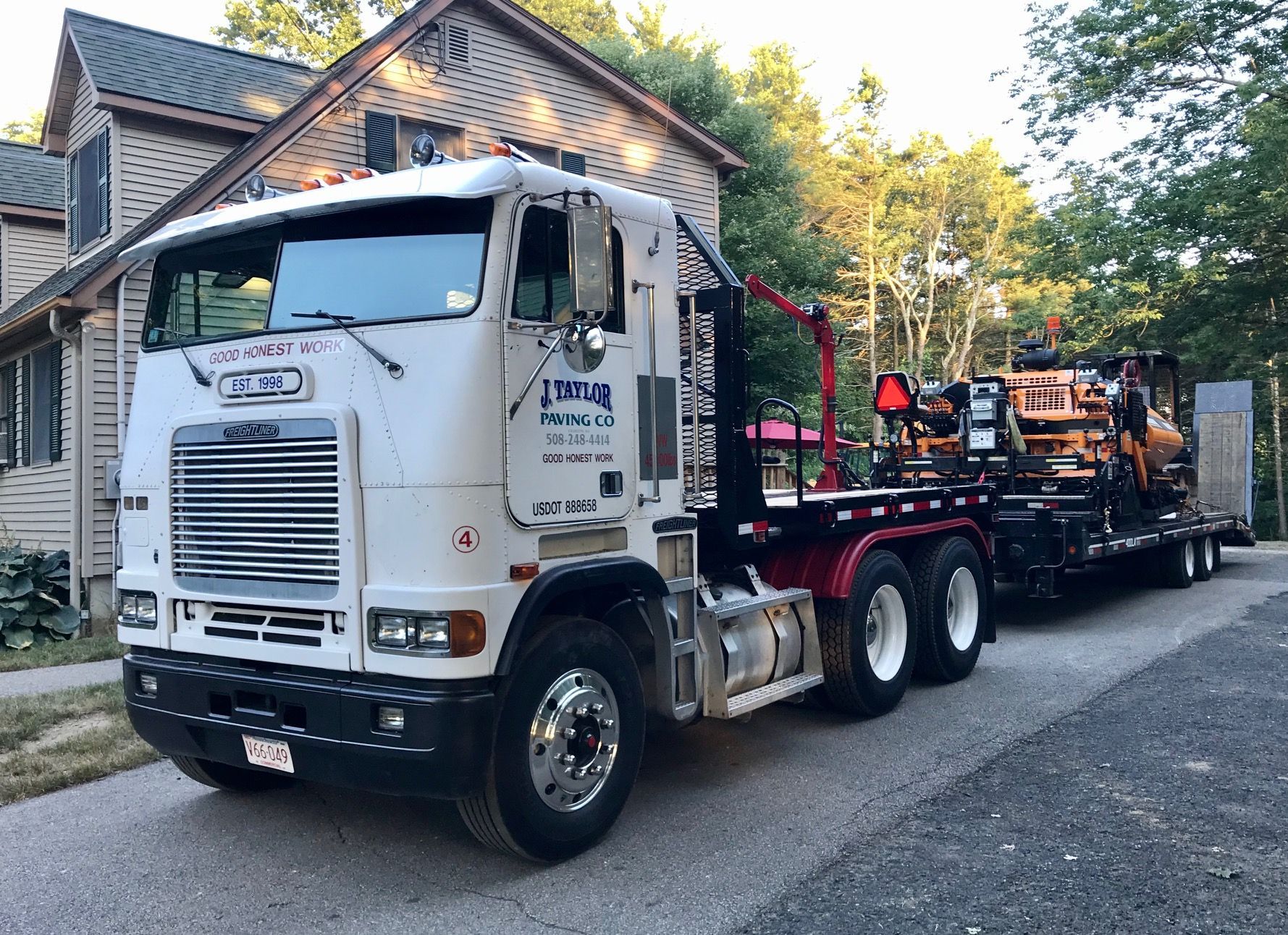 A white semi truck is parked in front of a house.