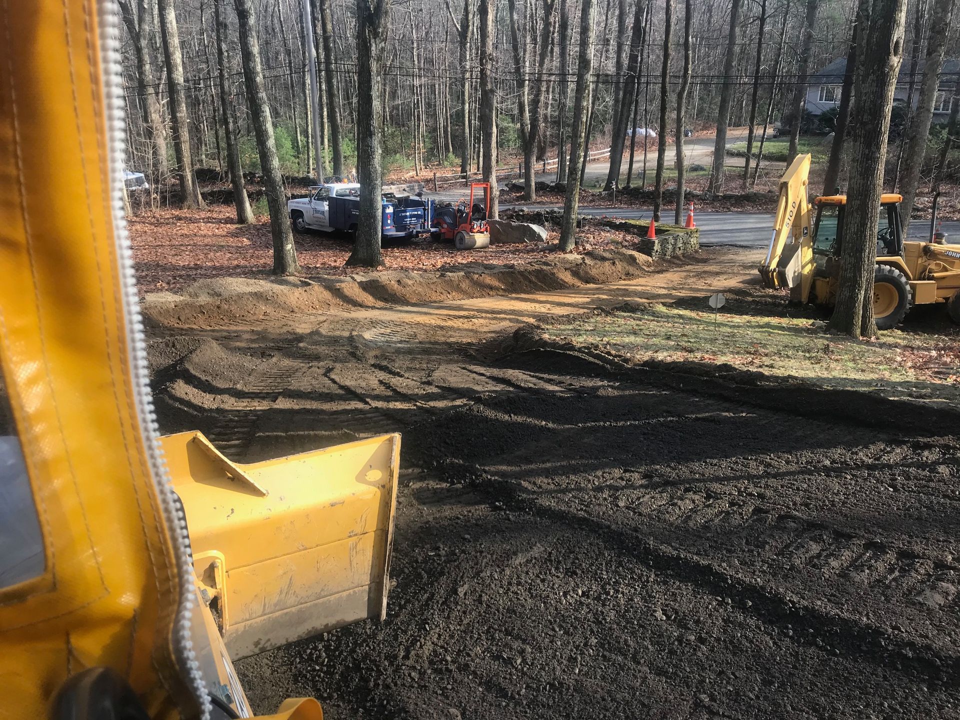 A yellow bulldozer is moving dirt in a forest.