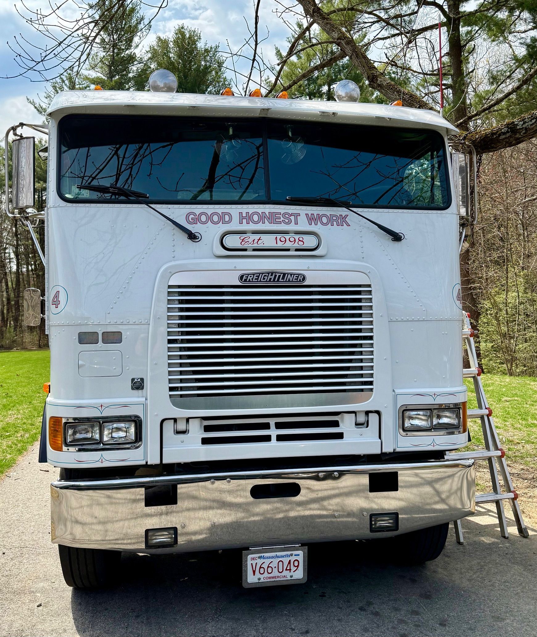 A white semi truck is parked on the side of the road.