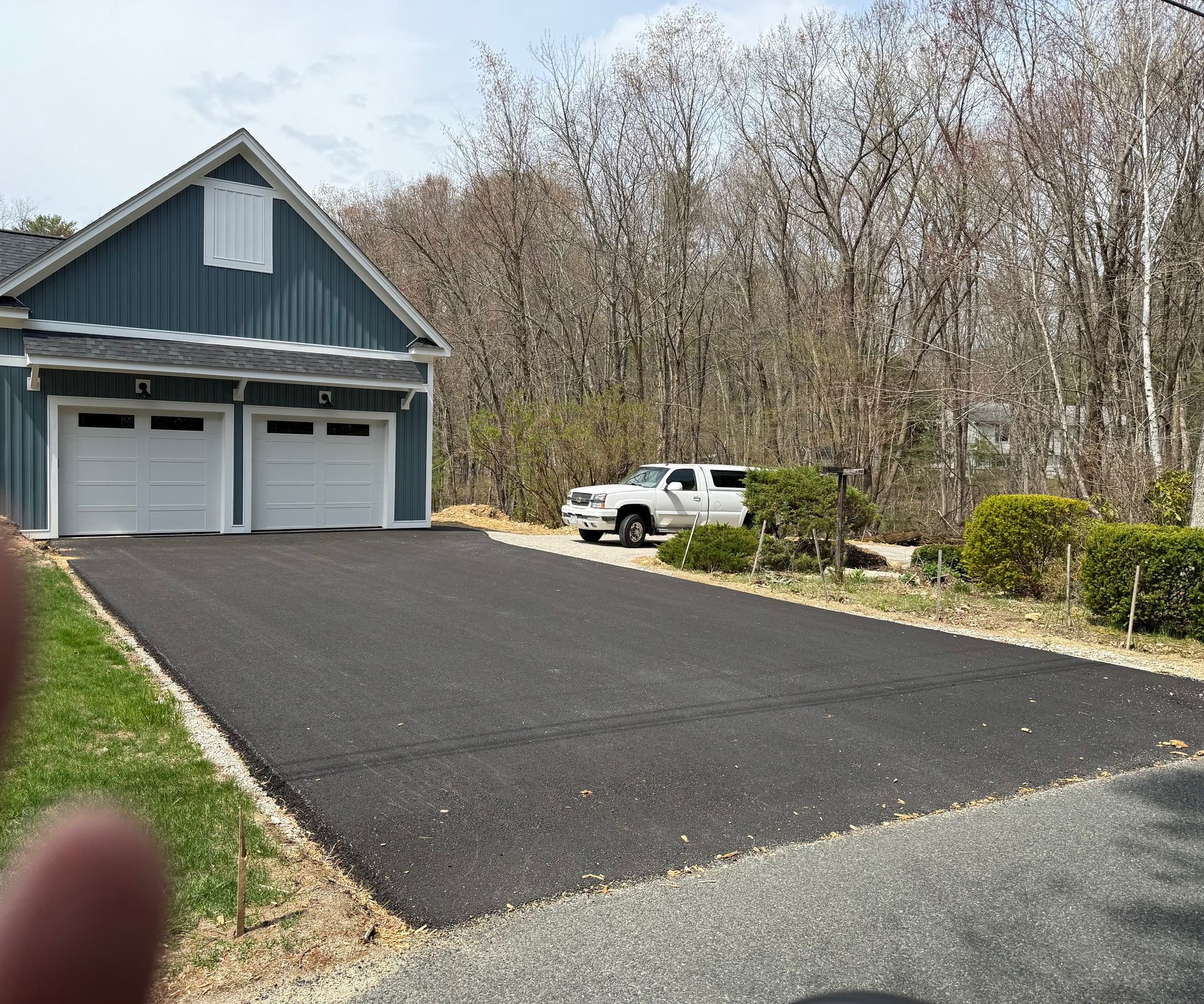 A white truck is parked in front of a garage.