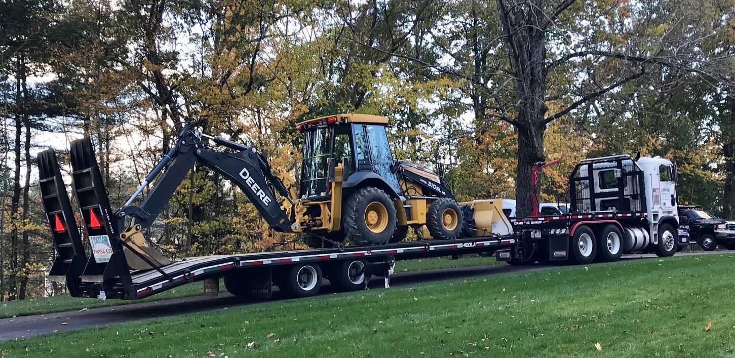 A tractor is being transported on a flatbed trailer.